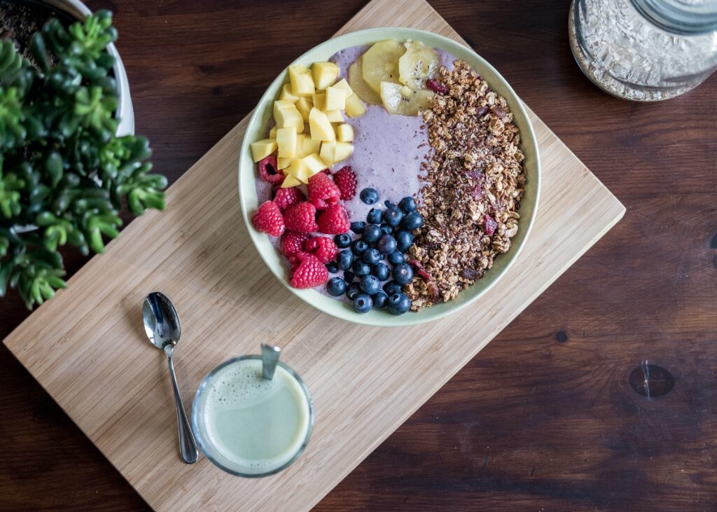 granola yogurt bowl on wooden cutting board